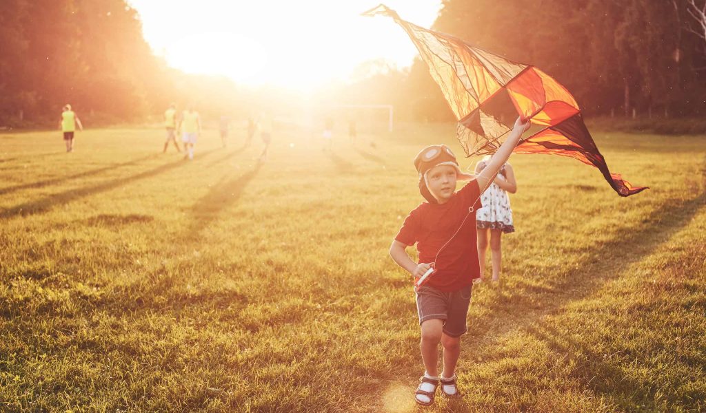 Happy children launch a kite in the field at sunset. Little boy and girl on summer vacation.